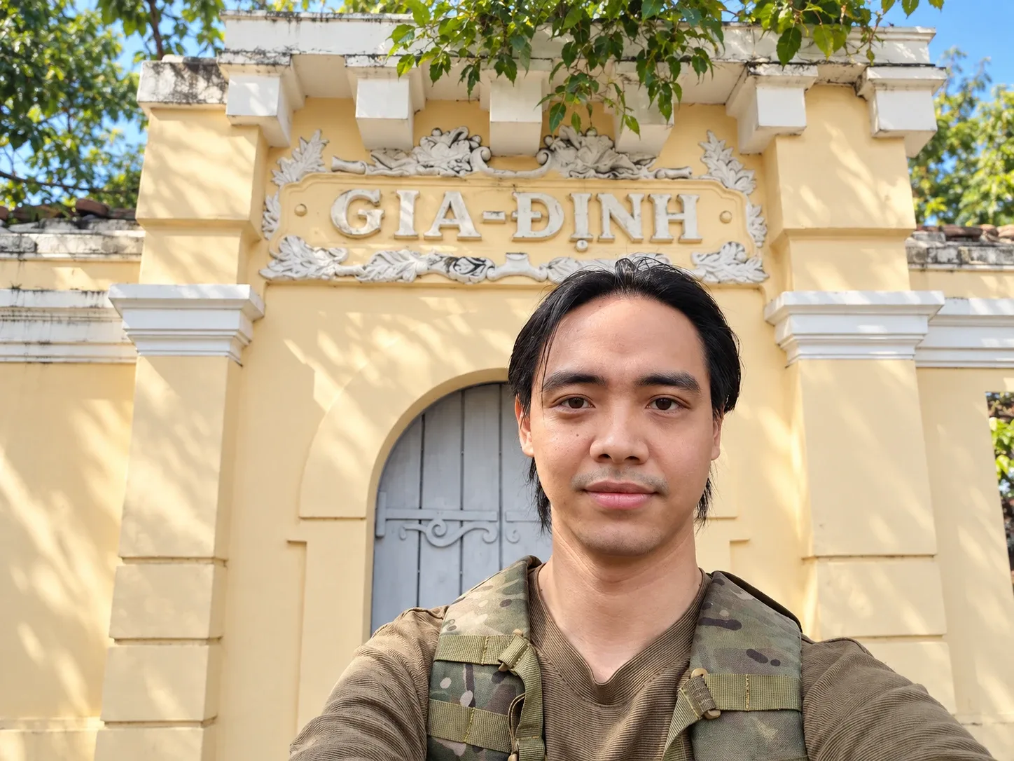 Tác giả Phạm Chí Hiếu trước cổng tường vàng có chữ “GIA-ĐỊNH”, được cho là còn sót lại của Gia Định xưa, gần Lăng Ông – Bà Chiểu
