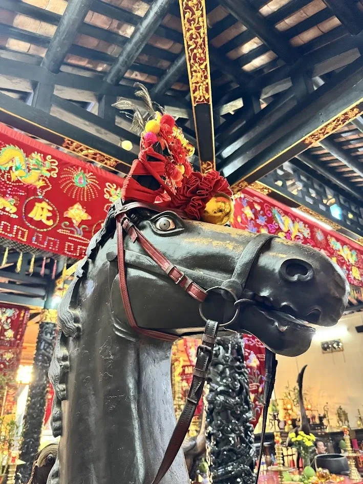 Tượng ngựa sơn đen thắng yên cương, đội hoa đỏ, trong chính điện Lăng Ông – Bà Chiểu